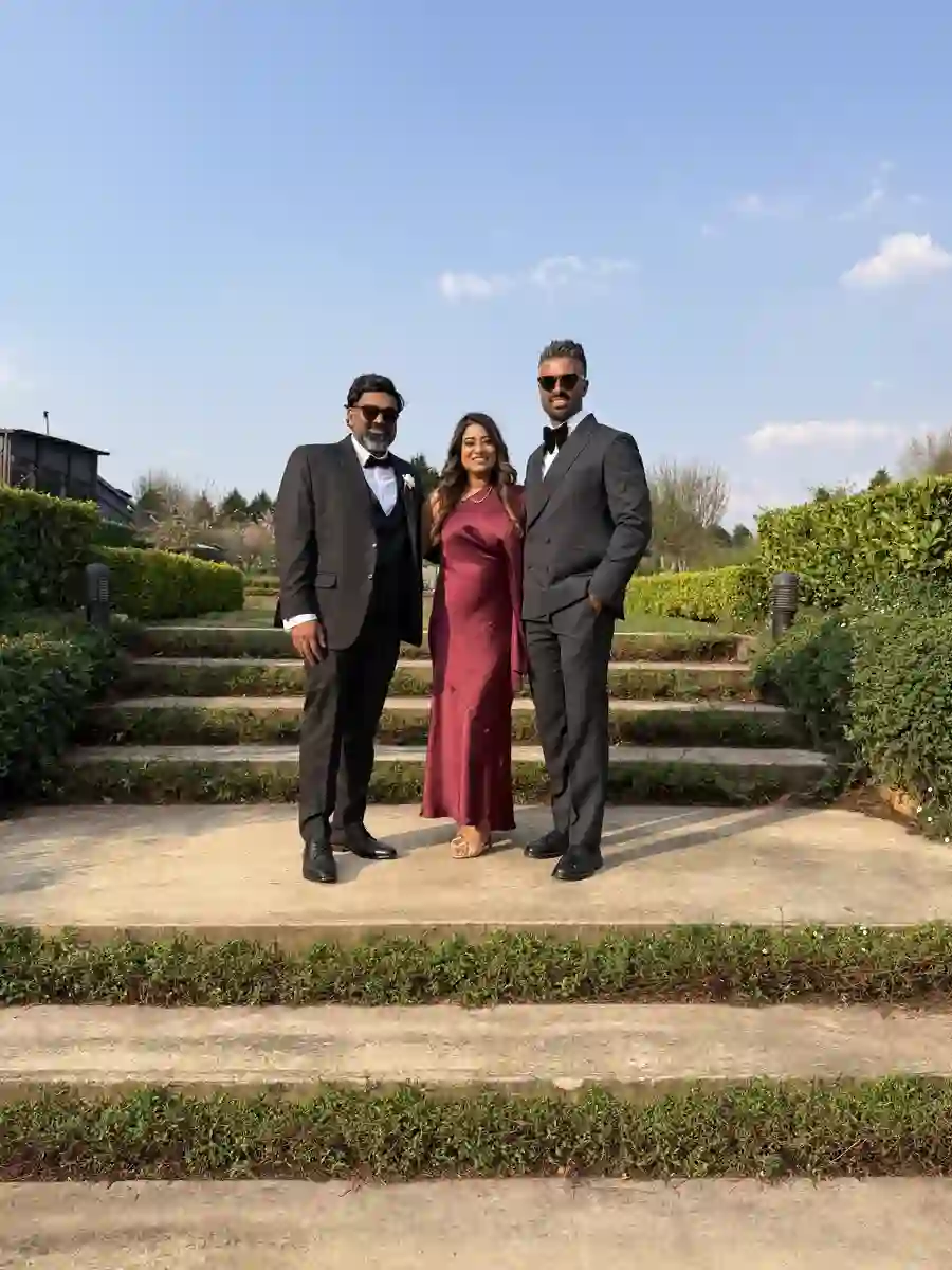 Phone snapshot of the same three guests on garden steps