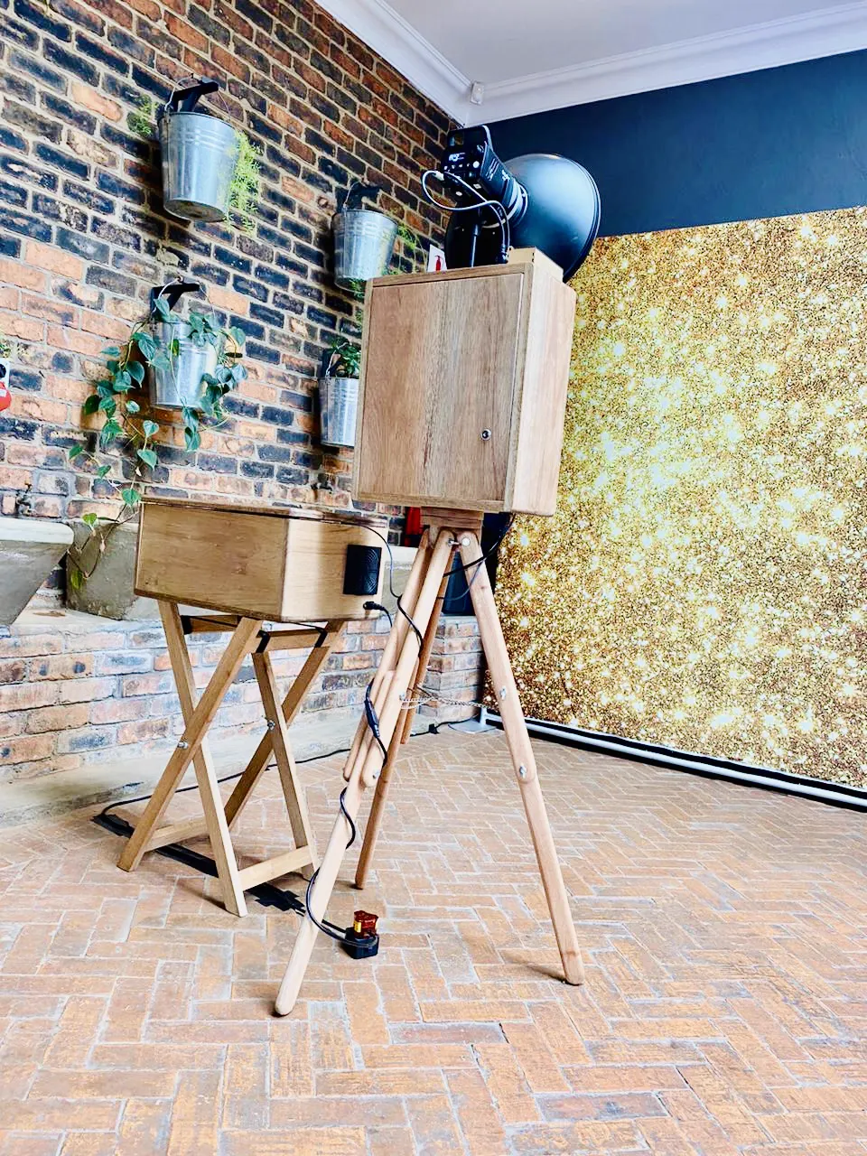 The Retrobooth and printer against an exposed brick wall and gold sequin backdrop at a Durban venue