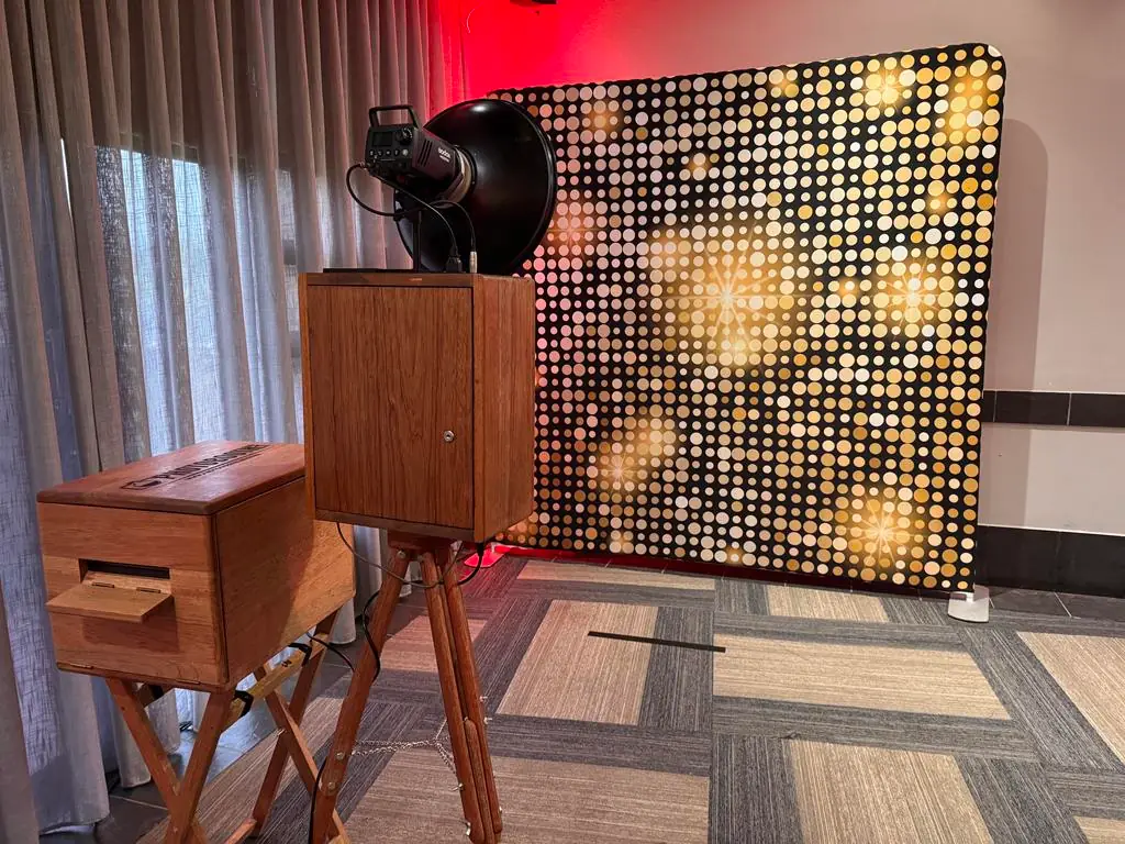 The Retrobooth and its printer set up against a gold sequin backdrop at a KZN event