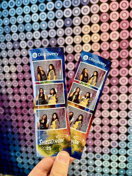 Discovery CANSA Shavathon branded photostrips held against a colourful dot backdrop