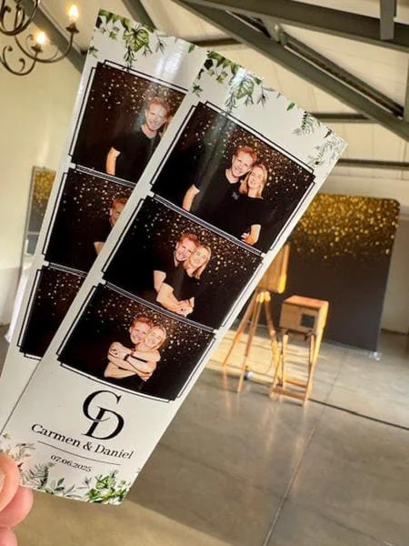 Carmen and Daniel botanical photostrips held up in front of the gold sequin backdrop at a KZN wedding