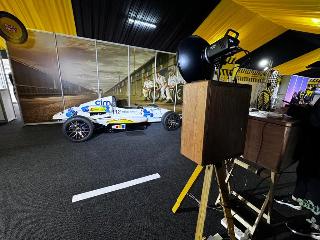 The retro photobooth set up at a corporate motorsport activation with a race car alongside