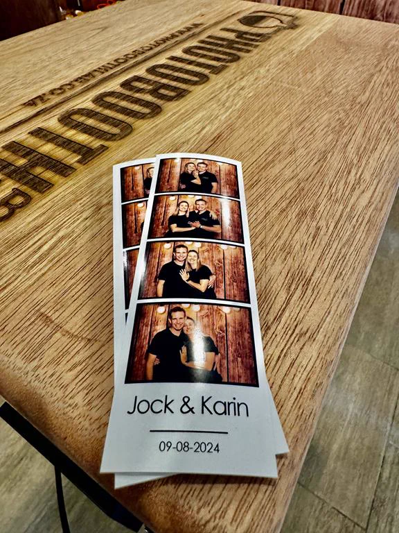 Jock and Karin wedding photostrips resting on the engraved wooden printer cabinet