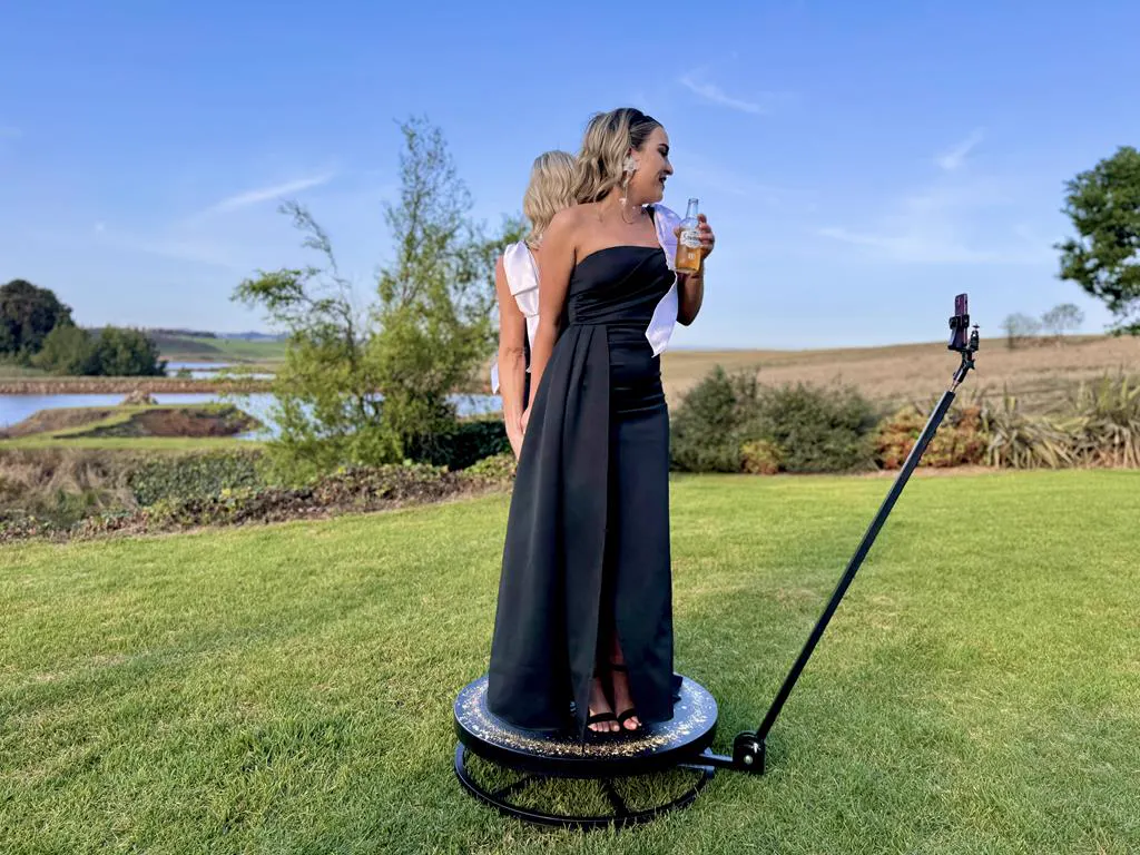 Guests in evening gowns filming a SPIN360 video on the lawn at a KZN country wedding venue
