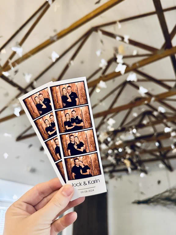 Jock and Karin photostrips held up beneath a hanging paper installation at a KZN wedding