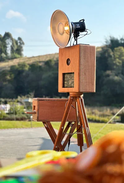 The Retrobooth on its wooden tripod on a Durban lawn with the KZN hills behind it