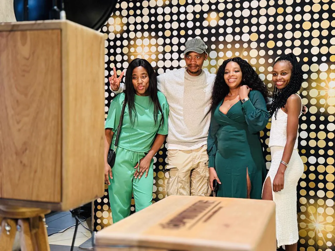 Four guests posing for the Retrobooth against a gold dot backdrop at a Durban function