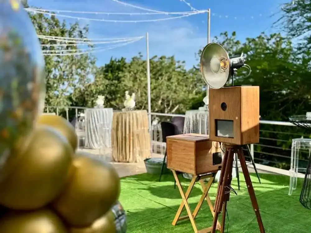 The Retrobooth and printer on astroturf beside gold balloons at an outdoor Durban function