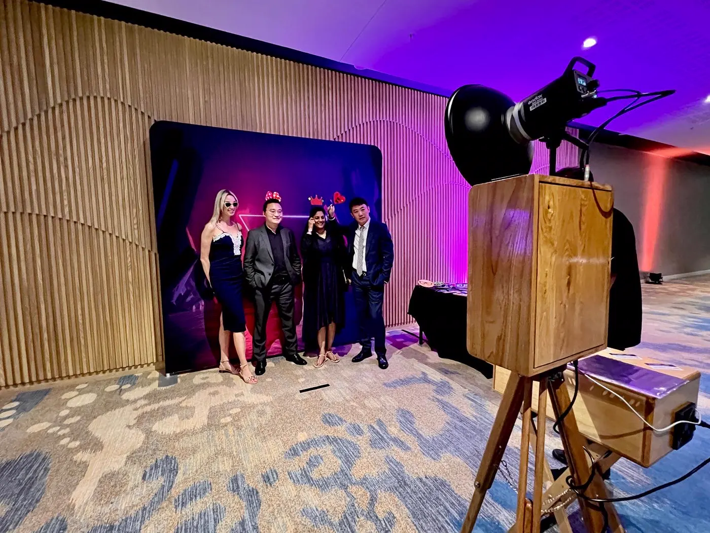 Four guests in formal dress posing with props at a corporate year-end function in Durban