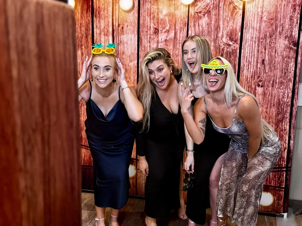 Four guests crowded into the Retrobooth retro photobooth with props at a Durban wedding